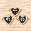 Detail of heart pendants with gold bows and black enamel on wooden surface - 10 Pieces Pack / Gold Black