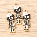Vue macro de trois pendentifs tête de mort en émail noir et chapeau doré avec étoile - Lot de 10 / Or Noir Blanc