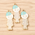 Détail de trois breloques squelettes avec chapeaux bleus pour la création de bijoux DIY - Lot de 10 / Or Blanc Vert