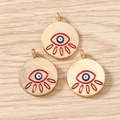 Detailed view of three golden devil's eye charms for jewelry making on wood - 10 Pieces Pack / Gold Red