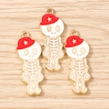 Detalle macro de colgantes de esqueleto con gorro rojo y estrellas doradas en madera - Paquete de 10 / Dorado Blanco Rojo