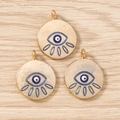 Macro view of gold-colored evil eye charms for jewelry making on wooden background - 10 Pieces Pack / Gold Blue