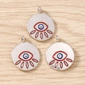 Close-up of three blue evil eye charms with silver metal rings on a light wood surface - 10 Pieces Pack / Silver Red