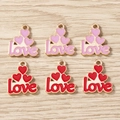 Dettaglio dei ciondoli LOVE in smalto con cuori per gioielli fai-da-te su legno chiaro - Multicolore