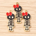 Detail view of skull charms with red bows and gold edges for DIY jewelry making projects - 10 Pieces Pack / Gold Black Red