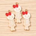 Macro detail of skeleton charms with red bows and enamel finish for DIY jewelry making - 10 Pieces Pack / Gold White Red