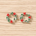 Detail view of festive green and red enamel holly wreath charms on a wooden surface - 5 Pieces / Silver