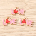 Makro-Detail von LOVE-Herz-Emaille-Anhängern für DIY-Schmuck und Ohrringe - Rosarot