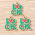 Macro detail of alloy lucky charms with green enamel luck text and red clover designs - Green