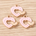 Close-up of pink enamel double heart charms with gold accents for DIY jewelry making - Pink