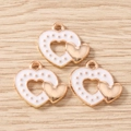 Close-up of three white enamel double heart pendants with golden dotted relief - White