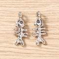 Macro-opname van gepolijste visgraat hangers voor doe-het-zelf sieraden op houten achtergrond - 5 Stuks / Zilver