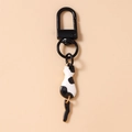 Close-up of cute black and white cow print cat keychain with black spring clasp and metal ring - Black and White Cat
