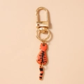 Detailed view of an orange cat keychain with a swinging tail and gold lobster clasp - Orange Cat