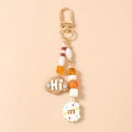 Detalle de llavero de cuentas con cierre dorado, charms de galleta y nube con letras - Marrón