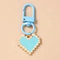 Detailed macro view of pixel art heart keychain with light blue finish and golden metal base - Blue