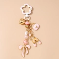 Detailansicht vom rosa Schleifen-Schlüsselanhänger mit goldenen Herzen und Ballettschuhen - Rosa