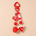 Close-up of strawberry cake keychain with red heart clasp and beaded charms - Heart Cake