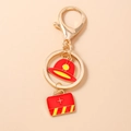 Detail of metal keychain featuring red firefighter helmet and medical kit charms - Helmet and First Aid Bag