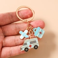 Détail d'un porte-clés médical avec ambulance, trousse de secours et pansement - Ambulance bleue