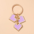 Detailed view of purple pixel heart keychain charms with gold metal rings and finish - Purple
