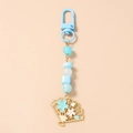 Detail of beaded keychain with blue square beads and golden cherry blossom fan pendant - Sky Blue