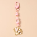 Close-up of beaded keychain with pink fan pendant and cherry blossom floral details - Pink
