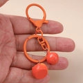 Detailansicht vom hellorangen Frucht-Schlüsselanhänger mit Glocke und Karabinerverschluss - Orange Mit Glocke Stil