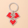 Detail of silver keychain featuring three retro red pixel heart enamel pendants - Red