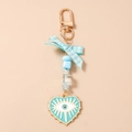 Détail du porte-clés avec nœud bleu, perles et pendentif cœur œil protecteur - Bleu