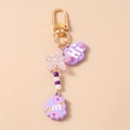 Dettaglio di un portachiavi viola con stella glitterata, nuvola HI e ciondolo M - Viola