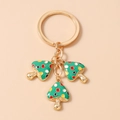 Detalle de llavero de champiñón dorado con esmalte verde y motas de colores vivos - Verde