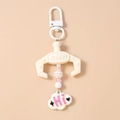 Close-up of a pink beaded claw machine keychain with cloud charm and Hi lettering - White