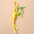 Detailed view of yellow braided rope and translucent green gummy bear charm pendant - Yellow