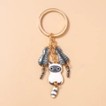 Detailweergave van cartoon katten sleutelhangers met gouden ring en emaille hangers - Grijs