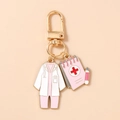 Detail of medical nurse uniform keychain with pink notepad charm and golden metal clip - Pink Medical Chart Uniform Style