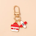 Detailed close-up of medical keychain with first aid kit and bandage charms in cartoon style - Red Kit Band-Aid Style