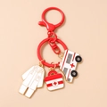Detailed macro view of medical charms including lab coat, first aid kit, and ambulance on a ring - Red