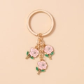 Detail of three pink enamel roses keychain with golden ring and small crystal accents - Pink