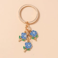 Detailed view of blue enamel roses with rhinestones on a gold-tone flower keychain - Blue