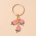 Detailed macro view of pink enamel rose charms with rhinestones on a gold keychain - Rose Red