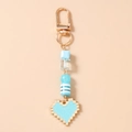 Detailopname van blauwe pixel hart sleutelhanger met gouden sluiting en kralen - Hemelsblauw