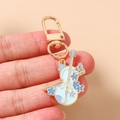 Vue macro d'un porte-clés violon doré avec des détails de fleurs en émail bleu - Violon bleu