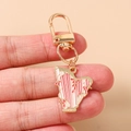 Détail d'un porte-clés harpe en émail rose et blanc avec dorure et motifs fleurs - Harpe Rose
