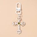 Detail of silver gothic cross keychain with olive green center gem and white lobster clasp - Silver Cross