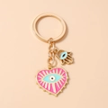 Detail of pink heart keychain with evil eye enamel and hamsa hand gold pendant - Rose Red
