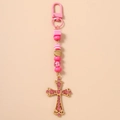 Dettaglio del ciondolo a croce con strass rosa e perline a righe su portachiavi dorato - Croce con Perline a Righe Rosa (条纹串珠十字架)