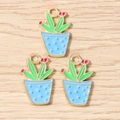 Flat lay detail of colorful enamel cactus charms on light wood texture background - Blue