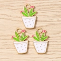 Detailed macro view of enamel cactus charms with gold plating and pink flowers - White