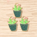 Detailed view of three green cactus enamel charms with pink flowers and gold alloy rings - Green